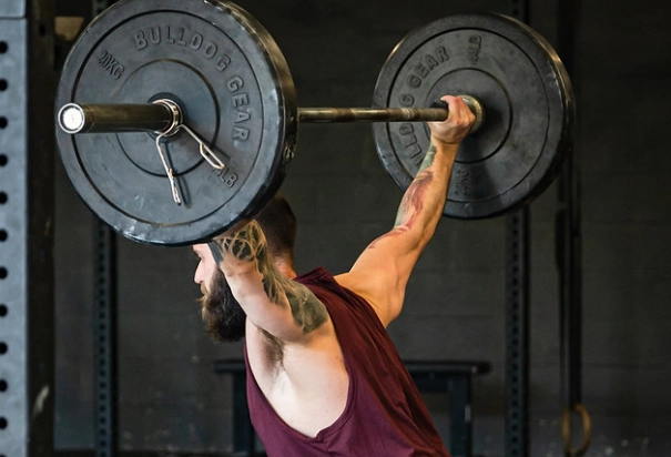 man in red shirt lift weight